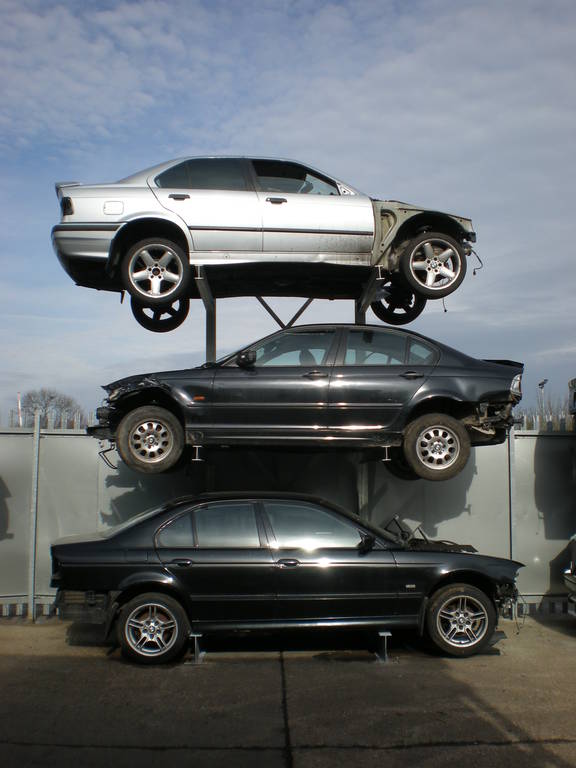 A car rack with three scrap cars on it