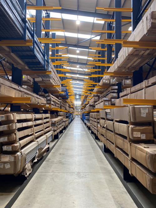 Cantilever racking with blue uprights and yellow arms storing long, boxed items